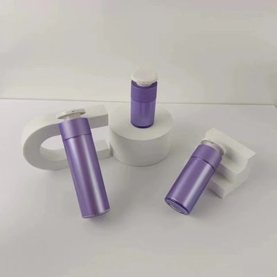 Paarse plastic cosmetische dispenserfles met witte drukknop pomp