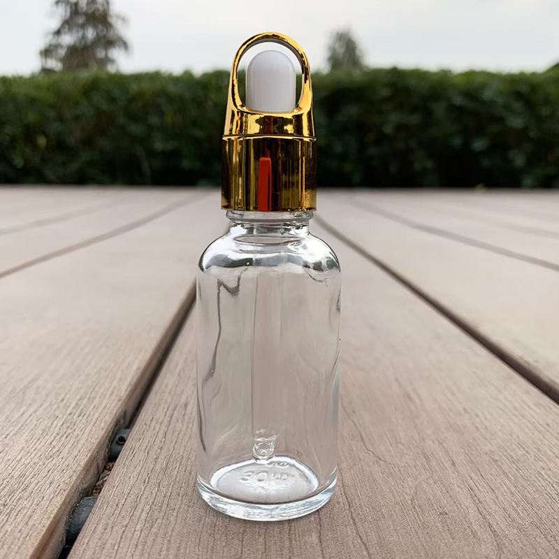 Doorzichtige glazen dropperfles met gouden dop